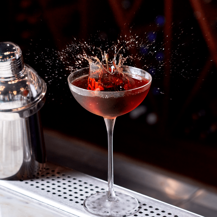 The splash of a cherry being dropped into a cocktail