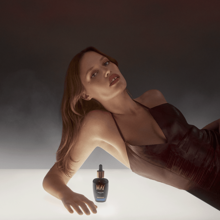 a woman laying down beside a bottle