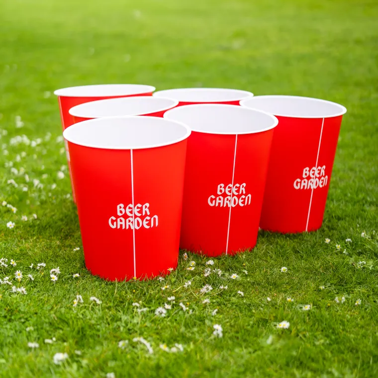 Red buckets with "Beer Garden" written in white sitting on a lawn