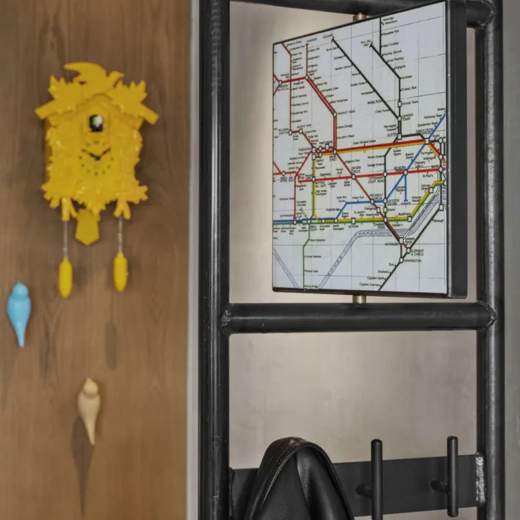 Coat hanger at entrance of room with a map of London on top