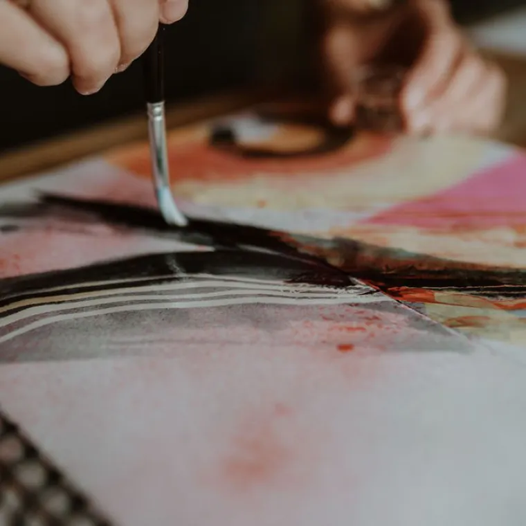 person painting in a notebook