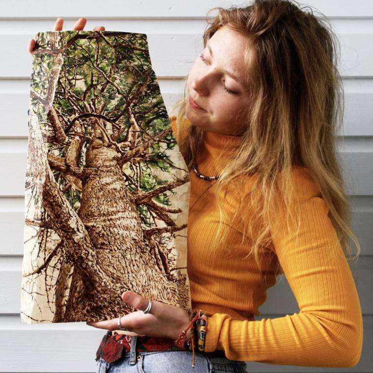 Tilia Holmes holding a painting of a tree