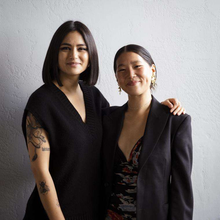 Two women in black posing