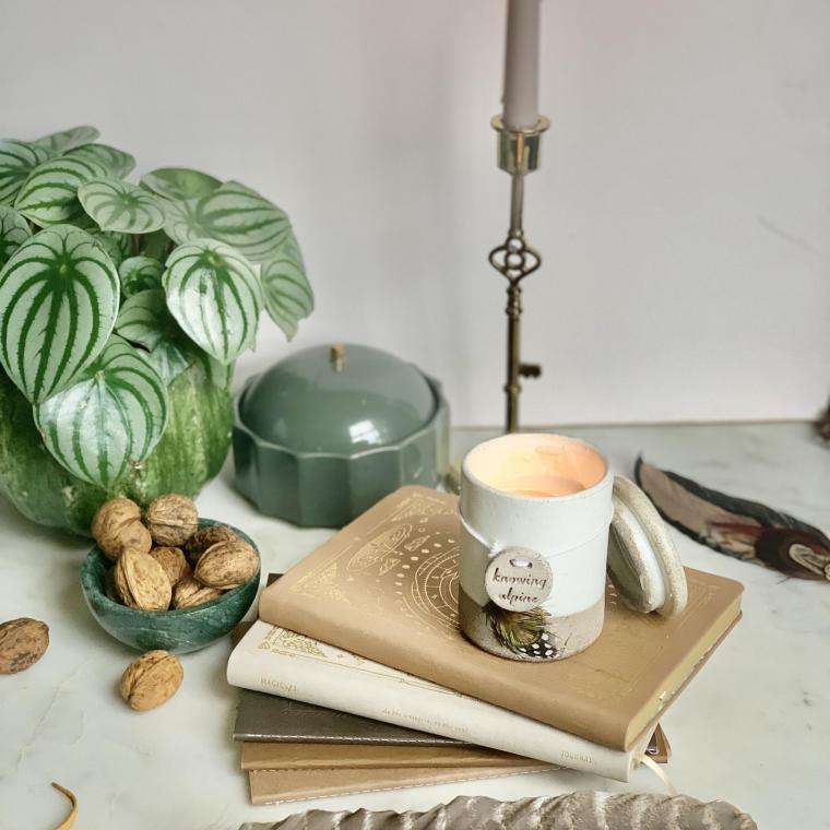 Womens Circle candle, feather, stack of old books