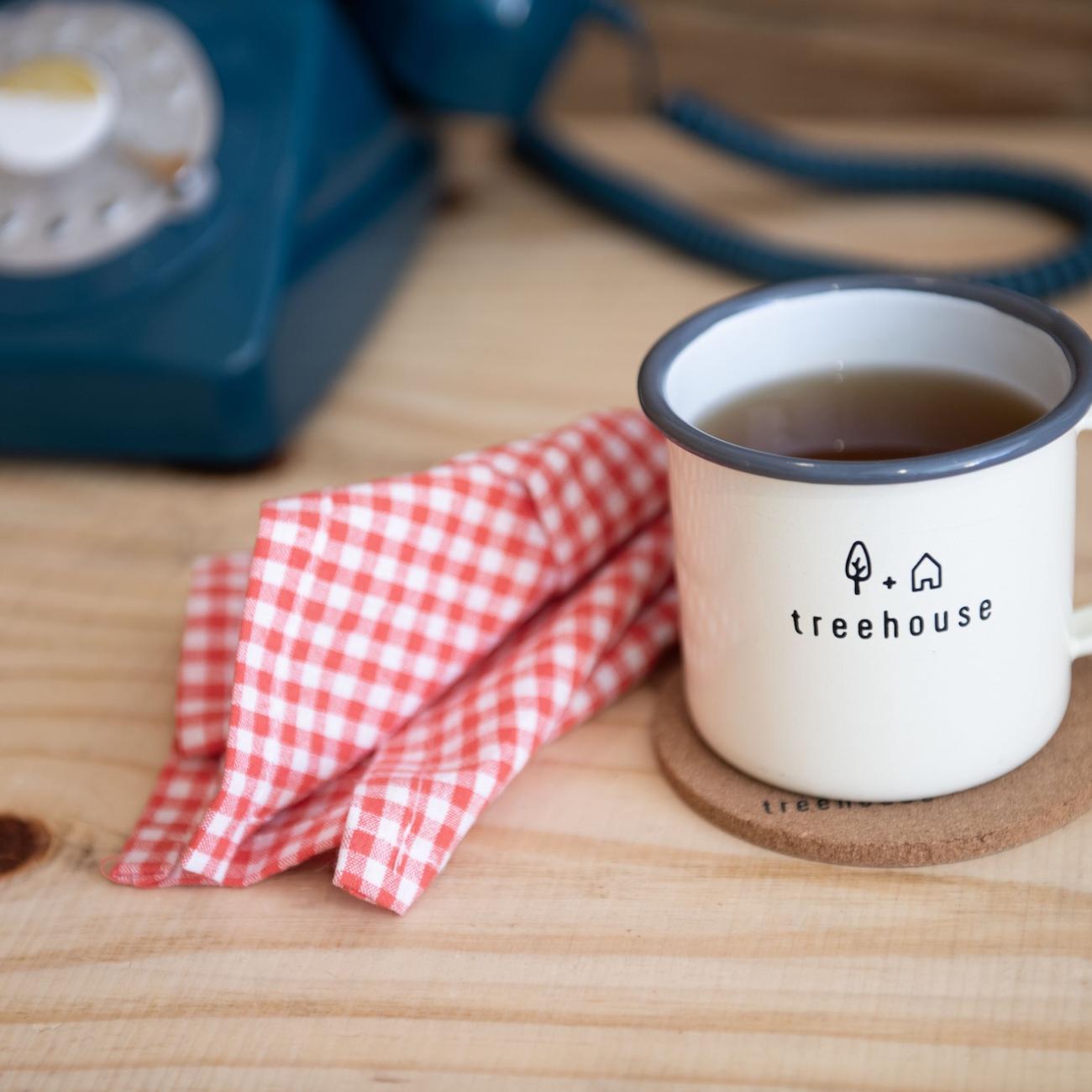 Treehouse mug full of coffee with a red and white napkin