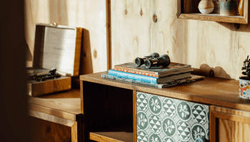 wooden storage cabinet with books on top