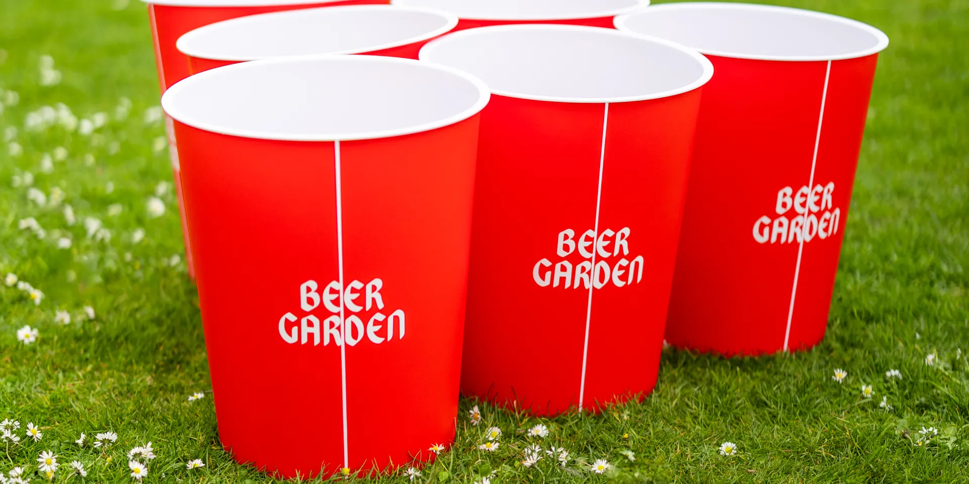 Red buckets with "Beer Garden" written in white sitting on a lawn